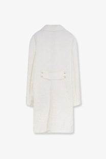 Back view of a cream-colored dolce and gabbana women’s brocade wool coat with textured fabric and gold buttons at the waist