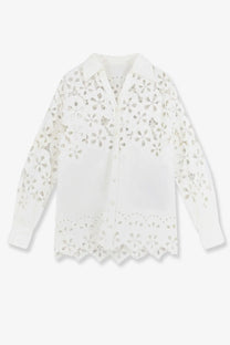 A delicate white cotton eyelet blouse by Dolce &amp; Gabbana with intricate floral cutouts on collar sleeves and hem