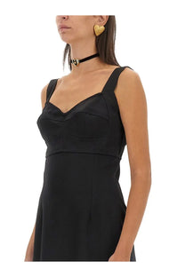 Dolce and gabbana women’s gold heart earrings paired with a black satin strapless dress with fitted bodice and pleating