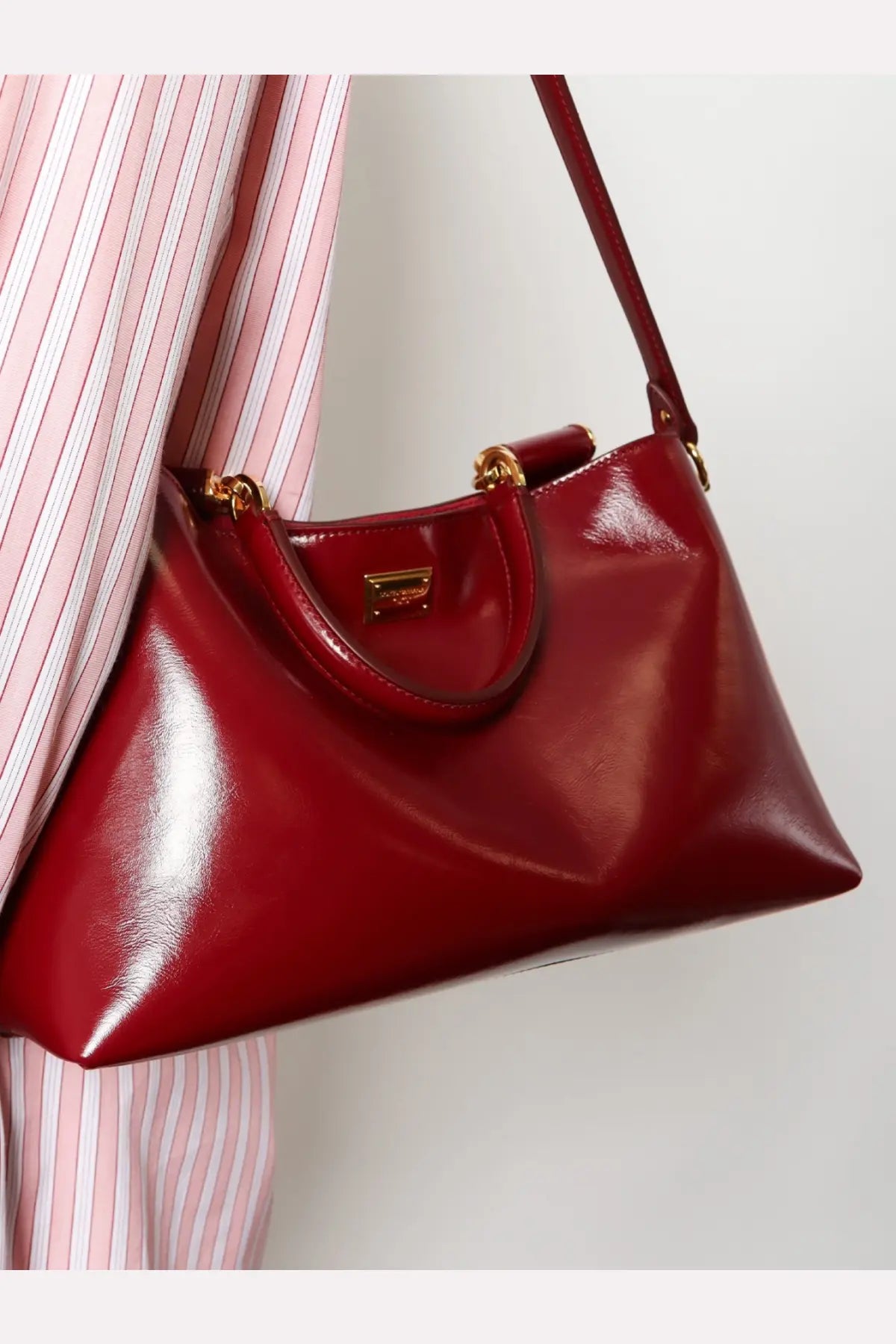 Dolce &amp; Gabbana women’s leather crossbody bag in glossy crimson with gold-tone hardware and a structured slouched silhouette