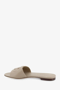 Beige leather slide sandal with minimalist design and subtle logo on strap from Dolce &amp; Gabbana women’s collection