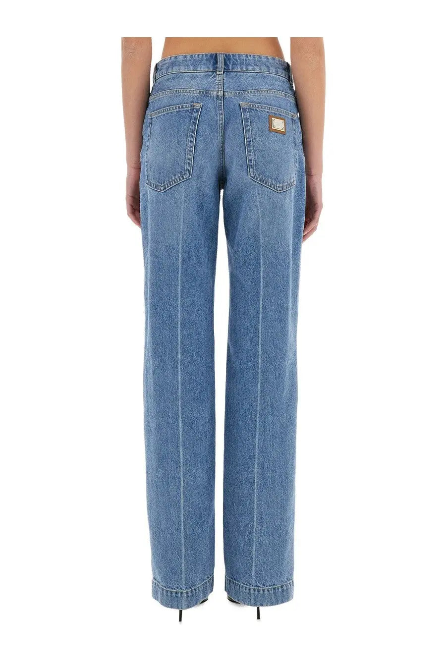 Back side of dolce &amp; gabbana women’s loose light-wash blue denim jeans with straight-leg cut and brown leather patch