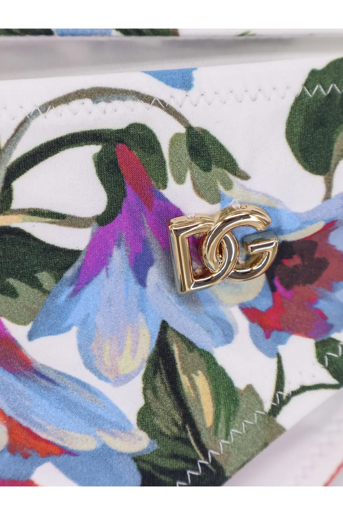 Gold-tone dg logo clasp on white nylon fabric with vibrant floral print on dolce and gabbana womens bikini