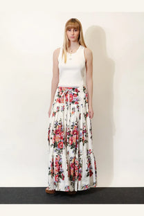 A flowing white maxi skirt with vibrant red pink and purple floral pattern paired with dolce and gabbana white ribbed cotton top