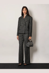 A structured double-breasted gray herringbone wool blazer with matching wide-leg trousers and a coordinating small handbag