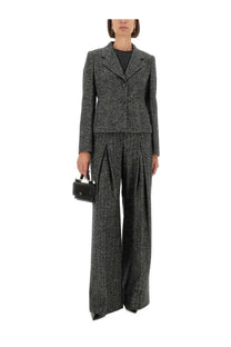 A black leather mini handbag with structured rectangular shape and silver toned hardware paired with dolce &amp; gabbana striped wool pants gray