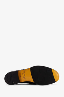 Black leather Doucal’s men’s Adler loafers with yellow rubber sole and Dougal’s brand name on inner side