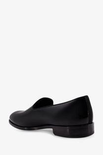 Doucal’s men’s black patent leather slip-on loafer with a sleek minimalist design and low block heel