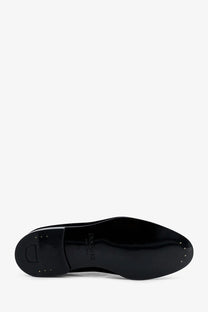 Black patent leather sole of doucal’s men’s velvet loafers with glossy finish and dior logo embossed on the back