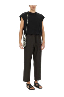 Black shoulder bag with snakeskin pattern and thin strap paired with dries van noten men’s black cotton shirt