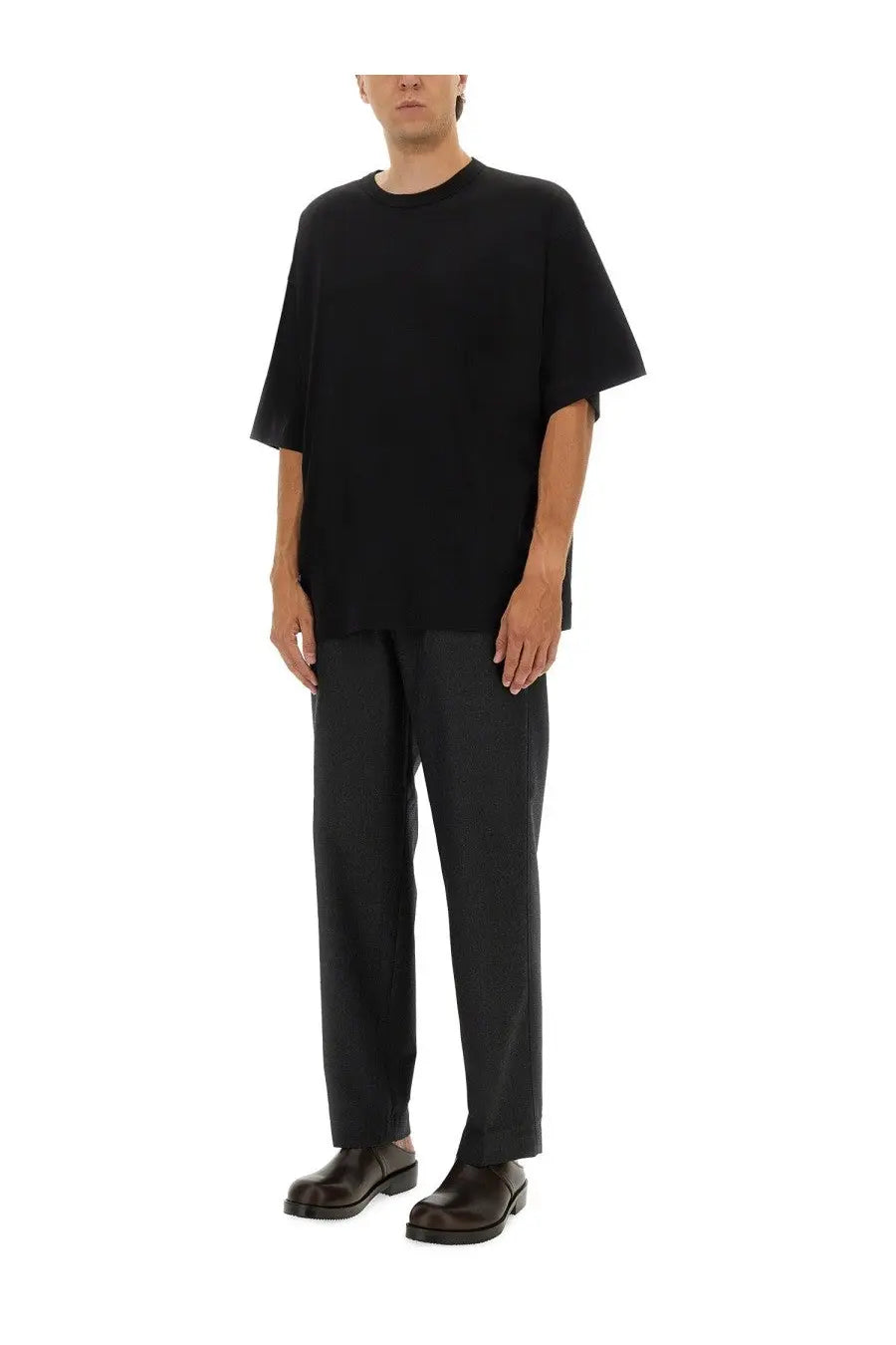 Black oversized short-sleeved t-shirt with relaxed fit and subtle hemline paired with dries van noten men’s penny grey pants