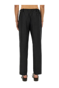 Black tapered Dries Van Noten men’s pants with drawstring waistband and subtle side pockets in penny grey