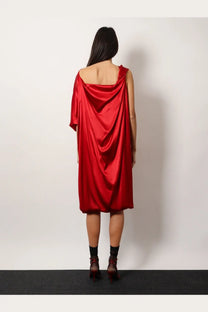 A flowing vibrant red satin dress with a draped off the shoulder design by Dries Van Noten