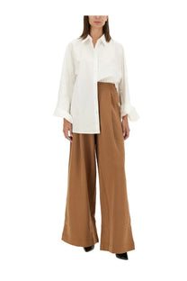 Dries Van Noten women’s brown jogging pants paired with a crisp white button-down shirt with rolled cuffs