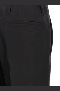 Black tailored trousers by dries van noten with sleek structured design subtle pleats at waistband in wool and silk