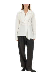 A white long-sleeved shirt with structured collar and asymmetrical front paired with Dries Van Noten grey pants