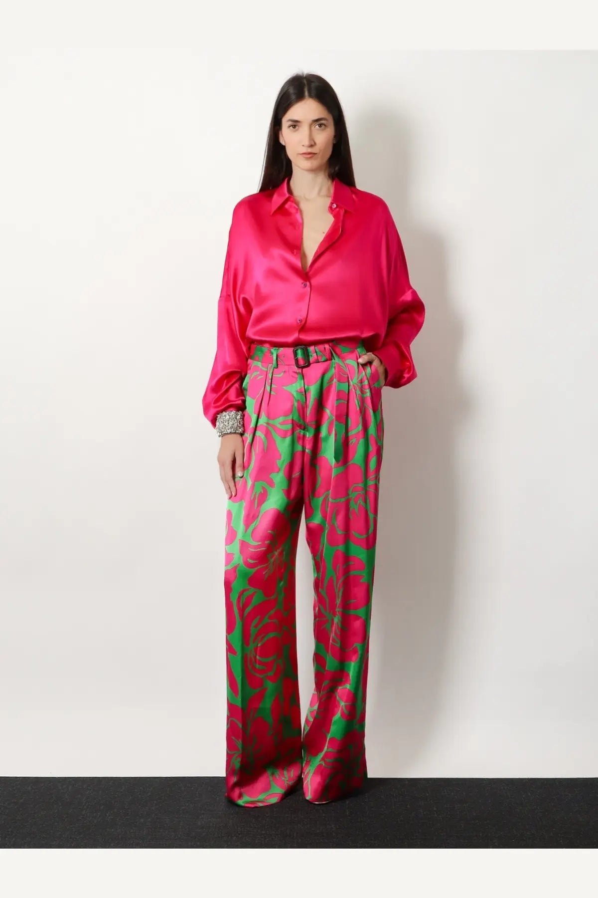 Vibrant fuchsia satin blouse with relaxed fit and button-down front paired with green viscose trousers by dries van noten
