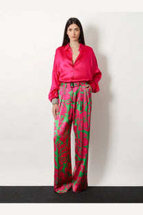 Vibrant fuchsia satin blouse with relaxed fit and button-down front paired with green viscose trousers by dries van noten