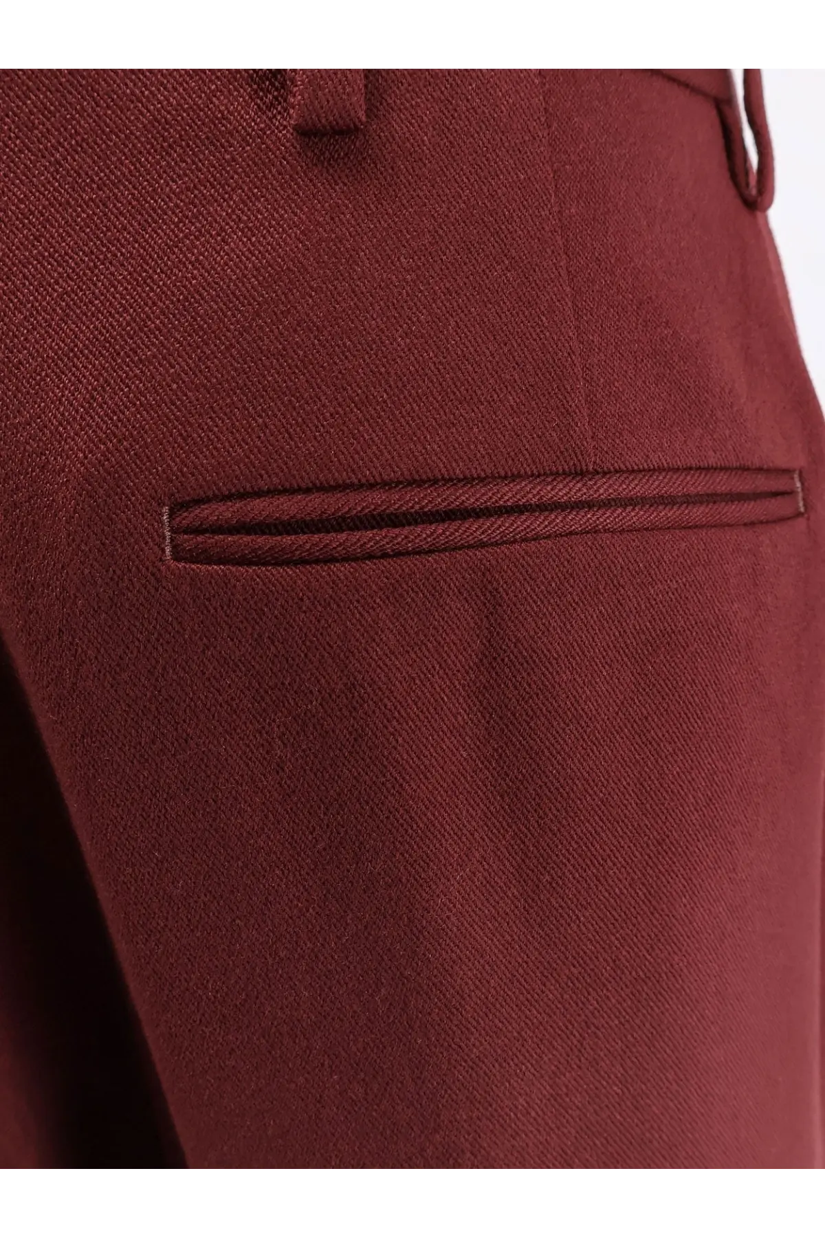 A close-up of dries van noten women’s portias wool trousers in rich burgundy with a diagonal weave and welt pockets
