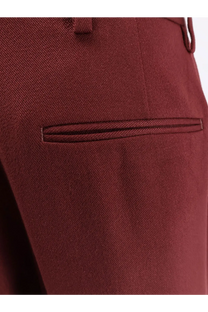 A close-up of dries van noten women’s portias wool trousers in rich burgundy with a diagonal weave and welt pockets