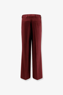 A pair of elegant wide-leg burgundy wool trousers with tailored fabric and subtle front pockets by dries van noten