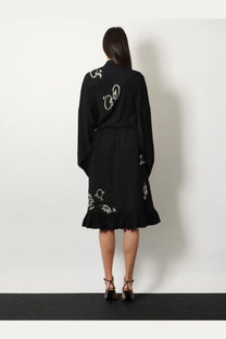 Black embroidered dress with white floral and bird motifs by dries van noten featuring intricate embroidery details