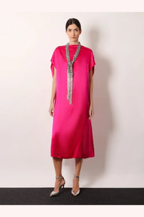A vibrant fuchsia satin midi dress with short cape sleeves paired with a Dries Van Noten silver beaded scarf necklace