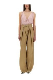 A soft pink satin top with deep v-neck and front tie detail paired with dries van noten beige wide leg pants