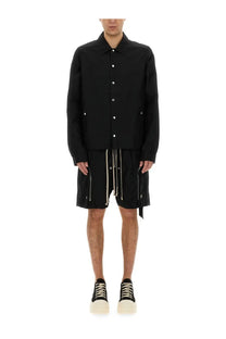 Drkshdw men’s black long-sleeved buttoned jacket with silver buttons and side pockets worn with matching shorts