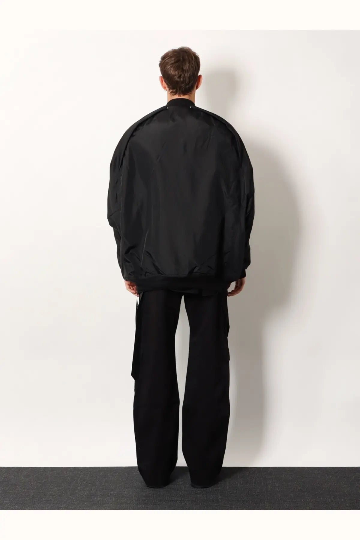 Black oversized bomber jacket with smooth reflective recycled nylon finish and subtle seam detailing by drkshdw
