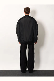 Black oversized bomber jacket with smooth reflective recycled nylon finish and subtle seam detailing by drkshdw