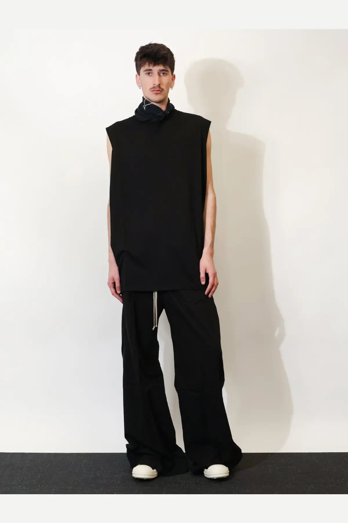 Black sleeveless top with high collar and relaxed fit paired with drkshdw men’s black cotton trousers