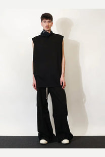 Black sleeveless top with high collar and relaxed fit paired with drkshdw men’s black cotton trousers