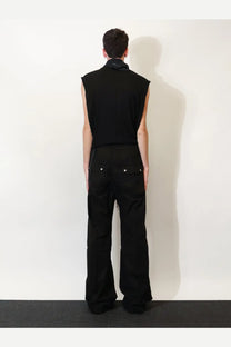 Black sleeveless top with high collar and subtle stitching paired with drkshdw men’s black cotton trousers