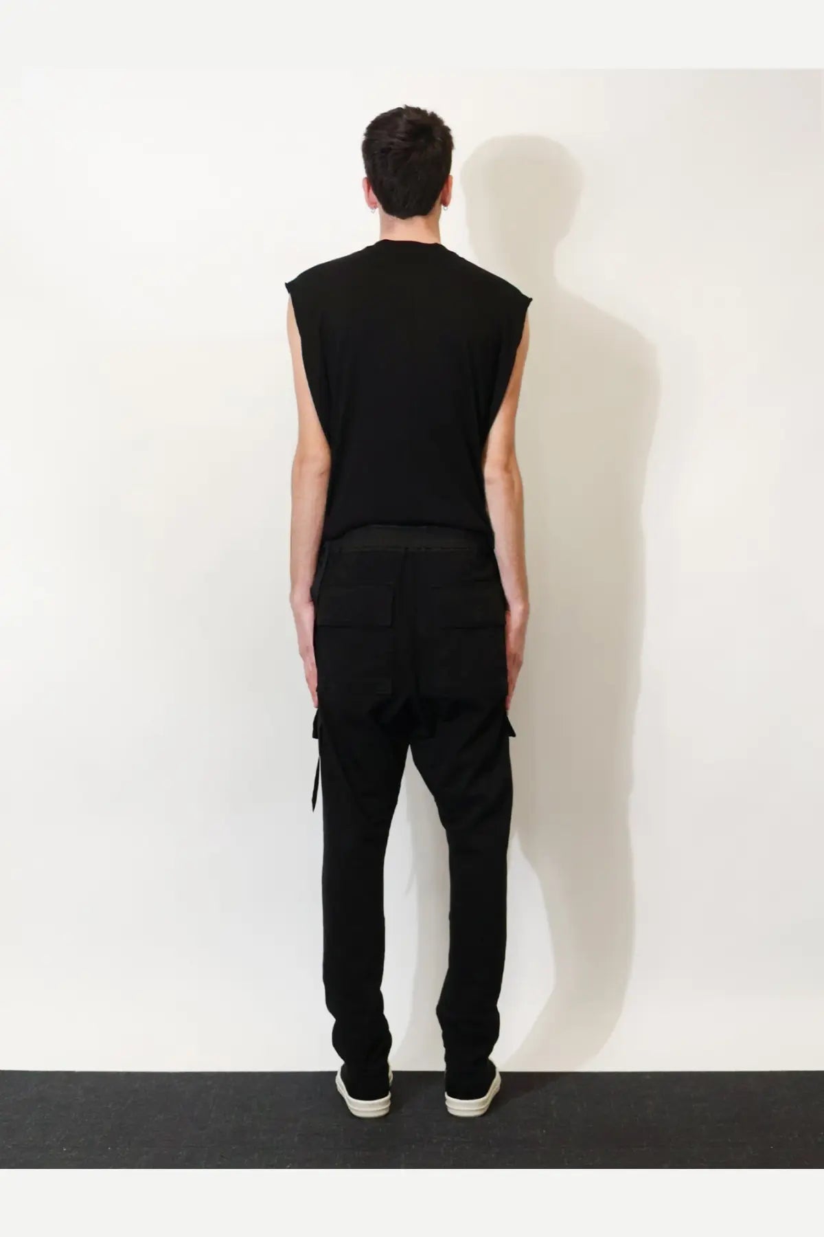 Black sleeveless top with relaxed fit and subtle side slits paired with drkshdw men’s black cotton trousers