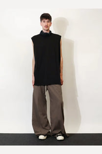 Black sleeveless top with high turned up collar and relaxed fit paired with drkshdw men’s grey cotton trousers