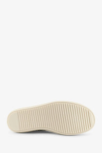 Cream-colored rubber sole with textured ribbed pattern on drkshdw men’s white denim sneakers back side