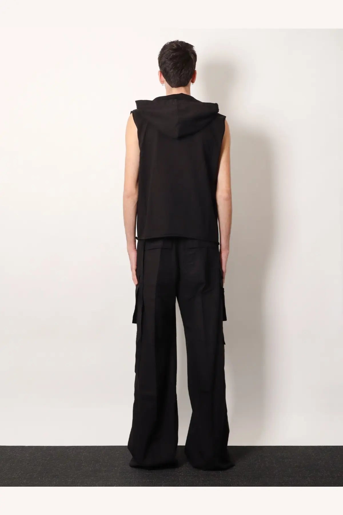 Black sleeveless hoodie with attached hood and relaxed fit paired with drkshdw men’s double cargo jumbo belas trousers black