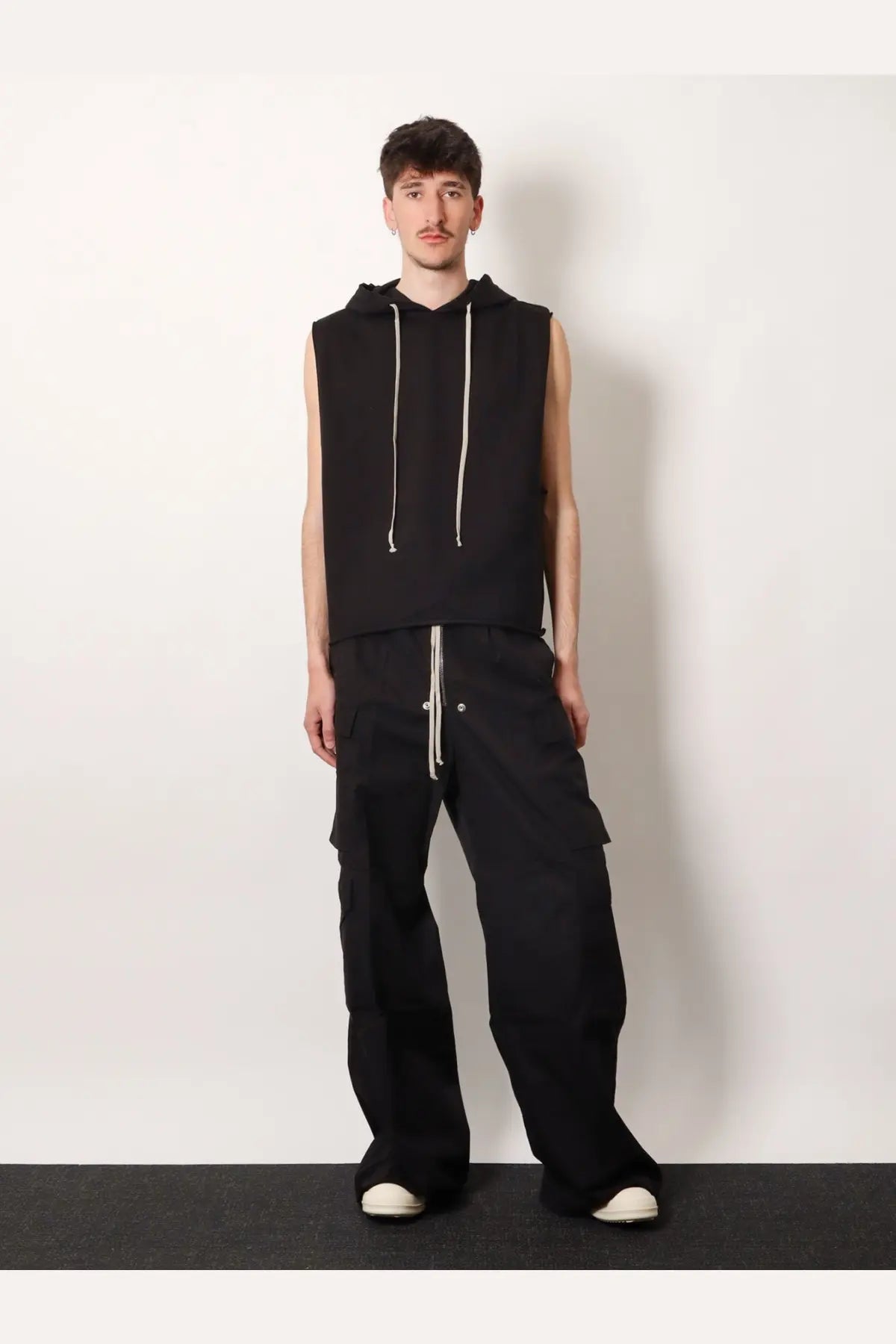 Black sleeveless hoodie with white drawstrings paired with drkshdw men’s double cargo jumbo belas trousers black