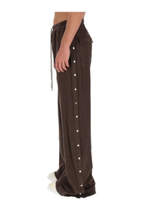 Drkshdw men’s brown wide-leg pants with drawstring waist and vertical white button row down the side