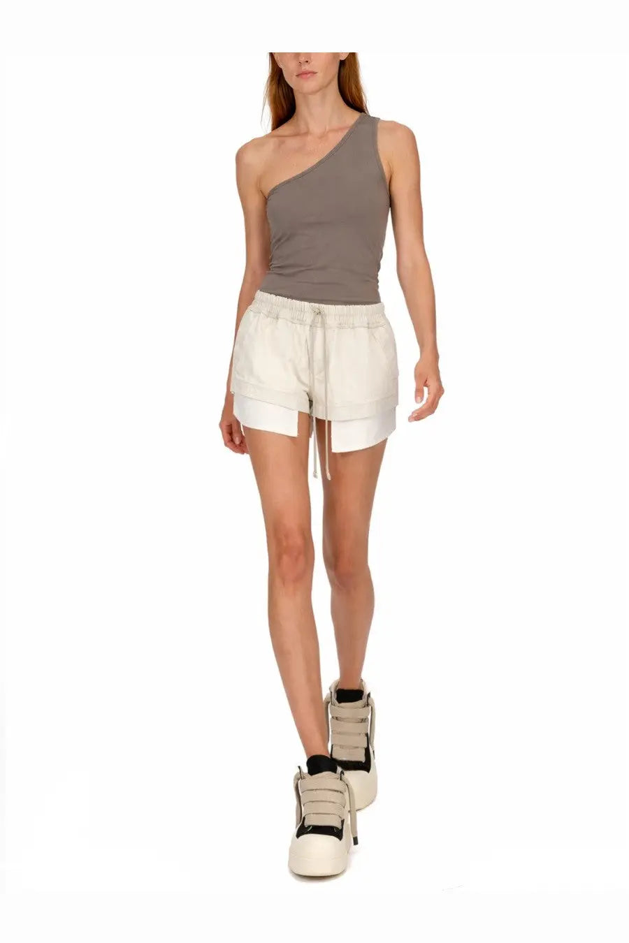 The model wears drkshdw women’s white denim shorts with inner layer and drawstring waistband paired with a gray tank top