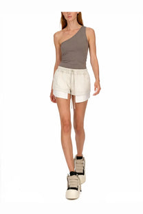 The model wears drkshdw women’s white denim shorts with inner layer and drawstring waistband paired with a gray tank top