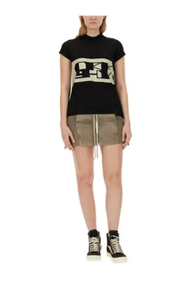 Black short sleeved t-shirt with bold cream abstract logo across chest paired with drkshdw women’s mini lido skirt blue