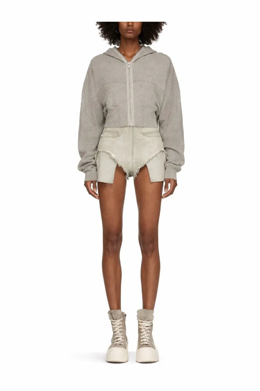 A gray cropped hoodie with front zipper and patch pockets worn over drkshdw women’s dirt beige distressed shorts