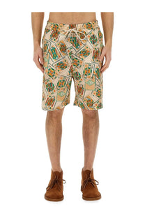Beige drôle de monsieur men’s bermuda shorts with a vibrant green and orange playing card pattern