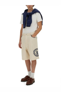 Beige cotton bermuda shorts by drôle de monsieur featuring a circular embroidered logo on the left leg