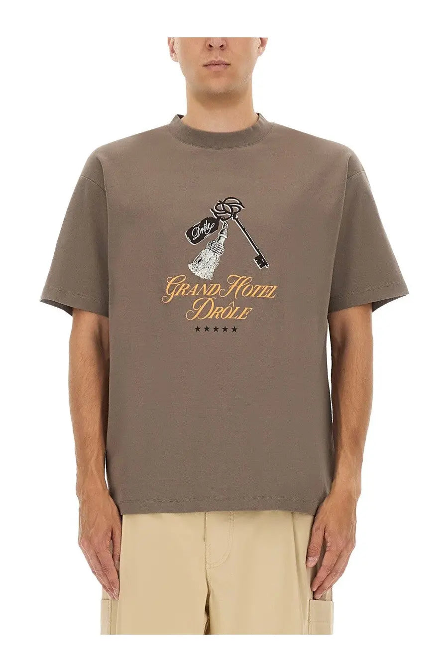 Drôle de Monsieur men’s taupe short-sleeved t-shirt with key and bottle graphic and grand hotel drôle gold text print