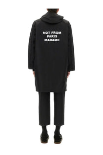 Back side of drôle de monsieur men’s black hooded parka coat with white not from paris madame text on the back