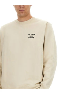Beige cotton crewneck sweatshirt by Drôle de Monsieur with black embroidered slogan not from paris madame on chest