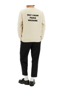 Cream-colored drôle de monsieur men’s sweatshirt with bold black slogan not from paris madame on the back